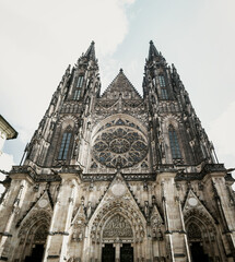 Fototapeta premium Low-angle view of the gothic facade of St. Vitus Cathedral within the Prague Castle complex in the Czech Republic.