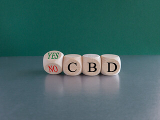 Yes or no to CBD, cannabidiol symbol. Turned the cube and changes words 'CBD no' to 'CBD yes'. Beautiful green background, copy space. Medical and CBD cannabidiol yes or no concept.
