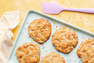 Homemade funfetti cookies on a plate in a yellow background