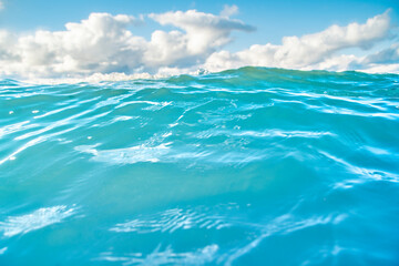 Panorama of a calm sea with clouds on the horizon. Background on the theme of summer vacation and ecology with copy space. Crystal clear ocean water.