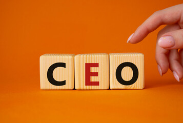 CEO - hief executive officer symbol. Concept word CEO on wooden cubes. Businessman hand. Beautiful orange background. Business and CEO concept. Copy space.