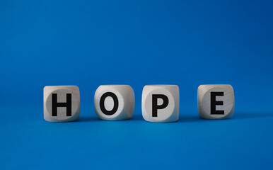Hope symbol. Concept word Hope on wooden cubes. Beautiful blue background. Business and Hope concept. Copy space.