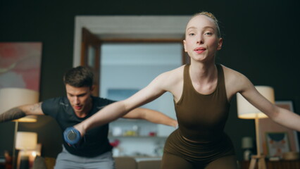 Family workout dumbbell home. Young couple exercising together for healthy body.