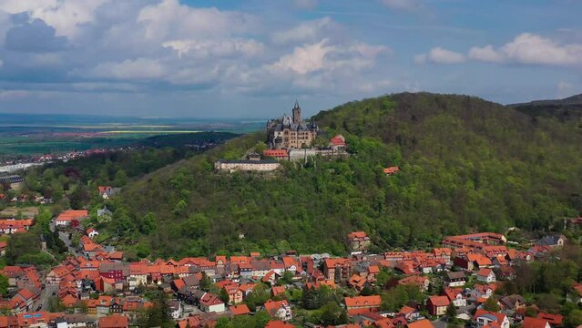 Aerial drone view medieval neogothic castle Wernigerode on mountain, Saxony Anhalt, Germany in sunny spring day. High quality 4k footage. High quality 4k footage