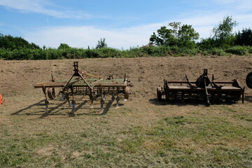 Fototapeta na wymiar FU 2022-05-15 Obstzeit 98 Auf dem Feld stehen alte landwirtschaftliche Geräte