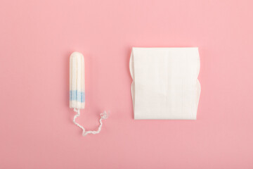 Tampon and sanitary pad on a pink background. Feminine hygiene products.