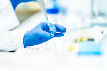 pipetting of chemical samples during research in a biochemical scientific laboratory