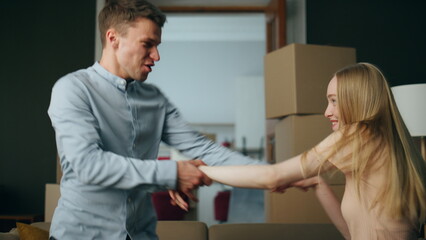 Fototapeta premium Happy couple dancing housewarming celebrating in own living room full close up.