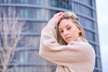 portrait of a blonde woman touching her hair in a sensual way looking at the camera