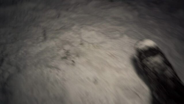 Boots on snow with a light illuminating and walking to a strange snow structure