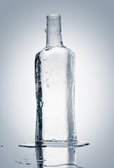 Melting piece of ice in the form of a glass bottle. Sculpture, made of clean ice. Purity and freshness concept.
