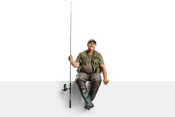 Mature fisherman with a fishing rod sitting on a blank panel