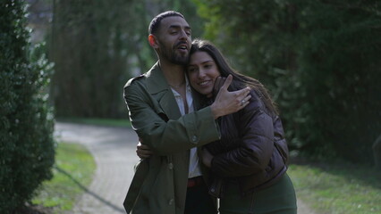 Obraz premium Joyful loving couple walking at park in romance. Boyfriend and girlfriend embrace while strolling outdoors