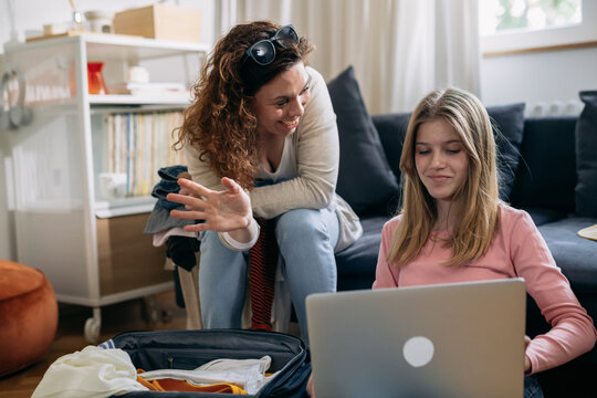 Mother and daughter are having a video call using laptop.