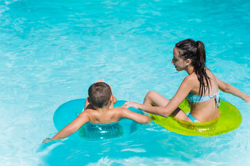 Two children in a pool with mats
