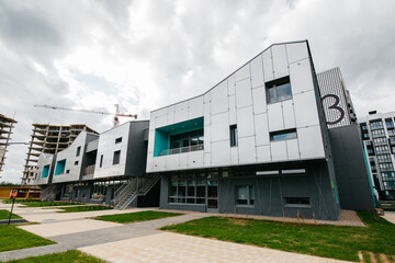 facade of a new modern kindergarten against the backdrop of residential real estate construction