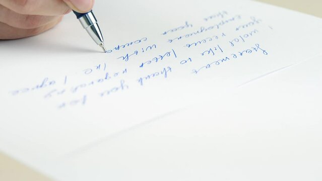 A close-up hand writes a business text on paper with a pen. Business and office work. Signing documents and writing agreements. deal in the office