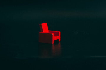 Red small wooden chair on a black background