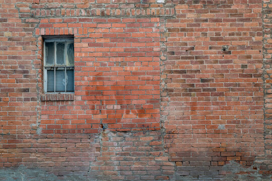 urban texture and background - grunge brick wall with a small, neglected window