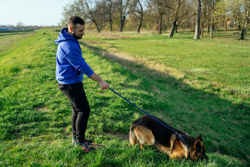Young Man Walking His Dog in Meadow