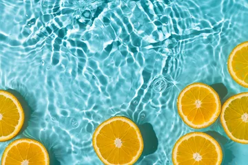 Poster Creative summer background with orange fruit slices in swimming pool water. Summer wallpaper with copy space. © Inna Dodor