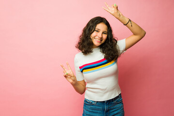 Cheerful teen girl smiling making the peace sign