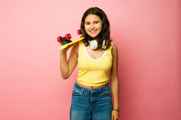 Portrait of a beautiful teenager with a retro skateboard