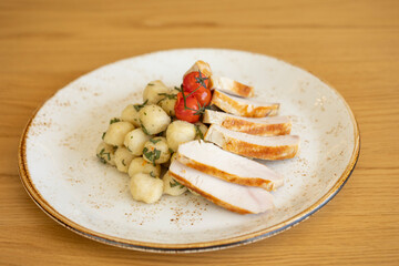 Grilled meat served with mashed potato balls and cherry tomato