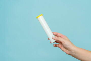 Tube for vitamins, pills in hand. Packaging. Mockup