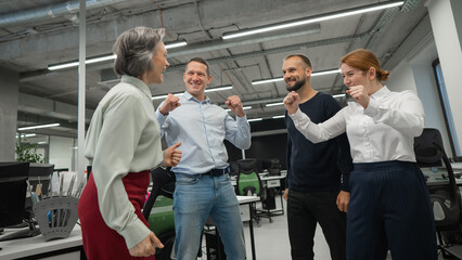 Four colleagues rejoice in success in the office.