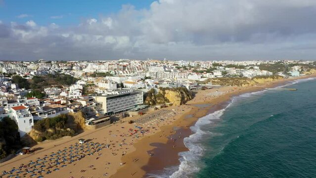 Aerial view of seaside Albufeira with wide beach and white architecture, Algarve, Portugal. Wide sandy beach in city of Albufeira, Algarve, Portugal. Aerial view of Albufeira town, Algarve, Portugal.