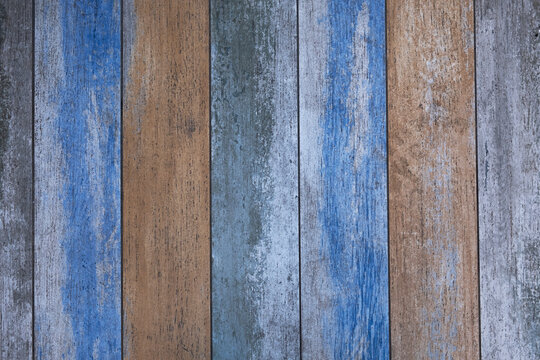 wooden boards with blue and beige paint and cracks. vertical lines. rough surface texture