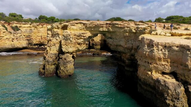 Natural arch above ocean, Arco de Albandeira, Algarve, Portugal. Stone arch at Praia de Albandeira, Lagoa, Algarve, Portugal. View of the natural arch Arco da Albandeira in the Algarve, Portugal.