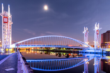 View of Millennium Bridge with blue skyline and full moon at UK