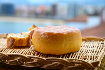 Spanish hard smoked cow cheese from Pria, Asturias, served outdoor with view on San Lorenzo beach in Gijon