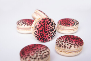 
Sweet raspberry and vanilla macaroons with leopard design on table
