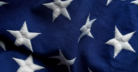 Panning across USA flag to the US American constitution written in 1787, ratified in 1788, starting with the words We The People, on old vintage paper or parchment. - Powered by Adobe