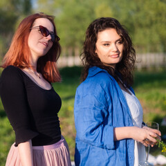 Two girlfriends portrait on a sunny day in nature