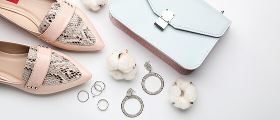 Set of female accessories with cotton flowers on light background
