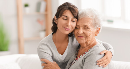 Happy elderly woman with her daughter at home - obrazy, fototapety, plakaty