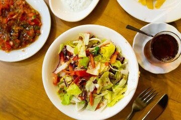 Turkish starter, salad made of lettuce and tomatoes, served on plate in restaurant.