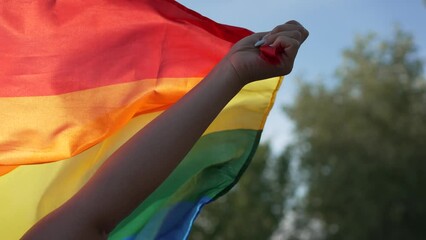 Video of an unrecognizable person's hand energetically raising a rainbow flag as a form of protest. LGTBIQ Concept - Powered by Adobe