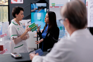 Pharmaceutical worker listening to customer complaint about aspiring medication near drugstore...