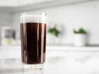 Brown soda in glass on table at the kitchen