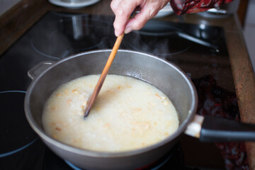 Senior woman stiring rice during cooking