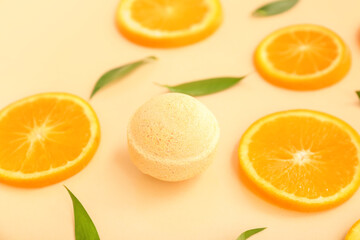 Bath bomb with orange slices and leaves on beige background