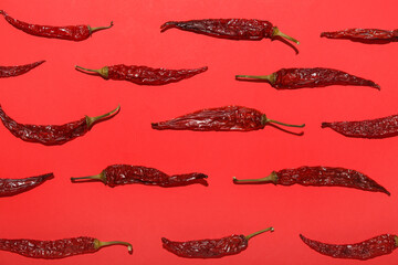 Dry hot chili peppers on red background