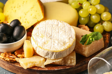 Plate with different types of tasty cheese on table, closeup