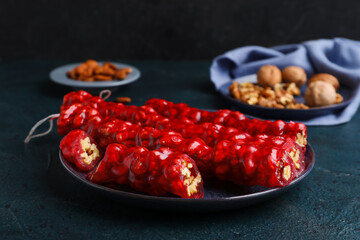 Plate with tasty churchkhela on dark background