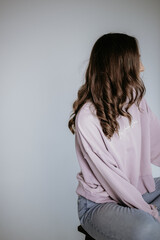 Posing of a girl with curls in the studio